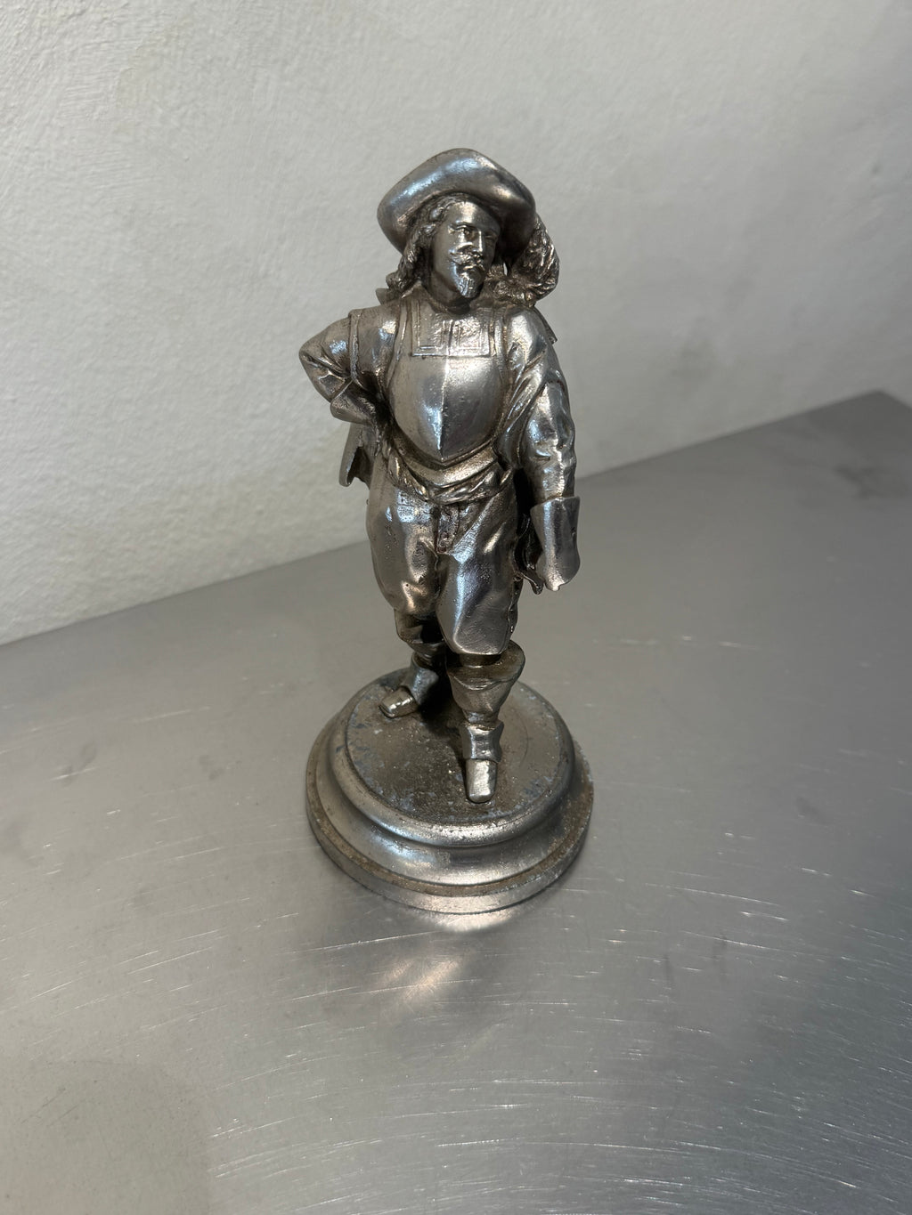 Metal musketeer figurine with age-related wear