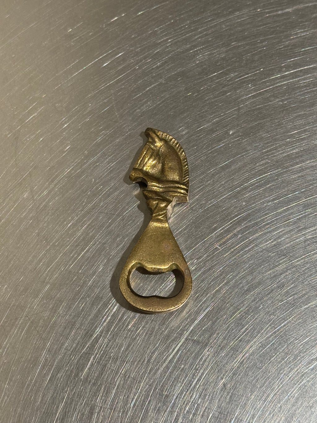 Brass horse bottle opener with patina