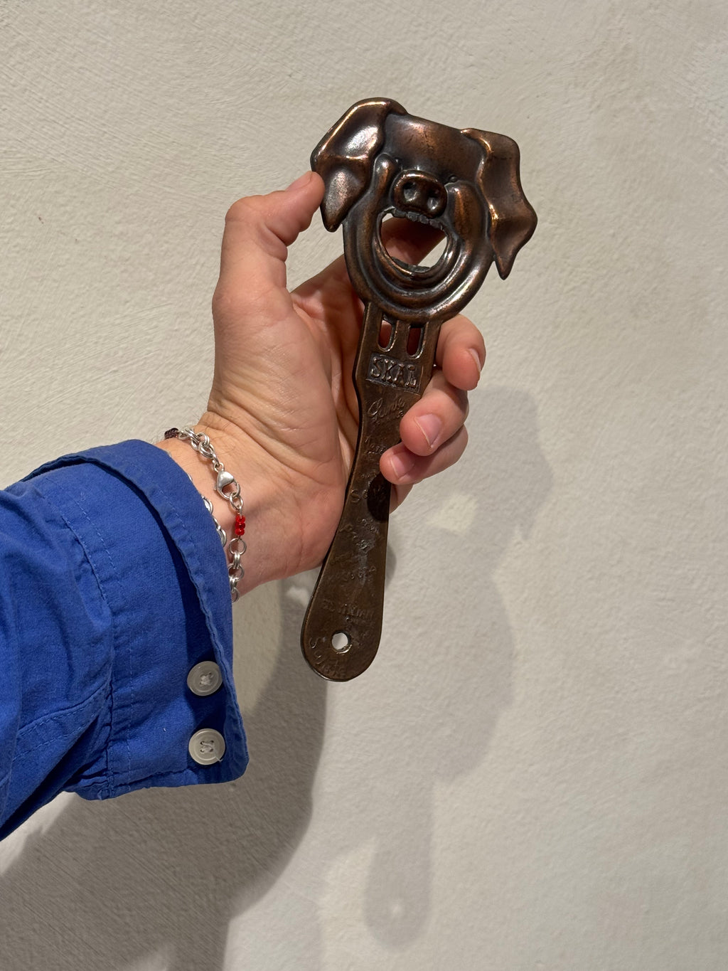 Large copper pig bottle opener with multilingual cheers markings