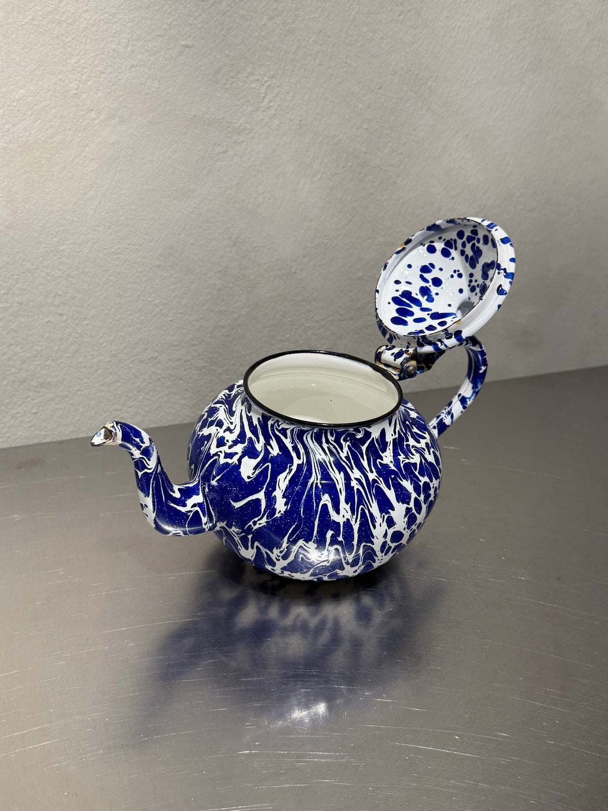 Antique enamel teapot detail with age wear