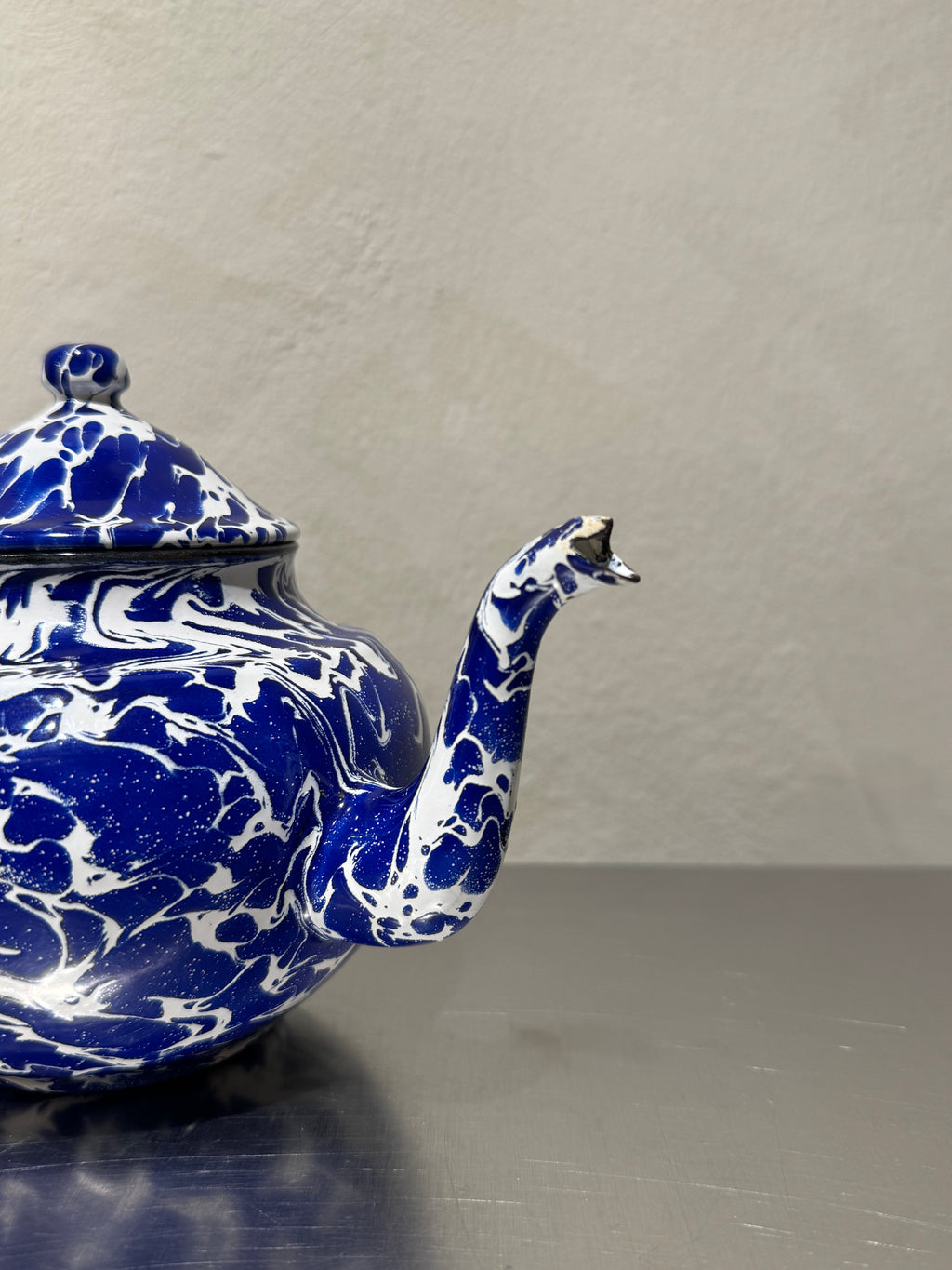 Blue and white marbled enamel teapot with chipped spout
