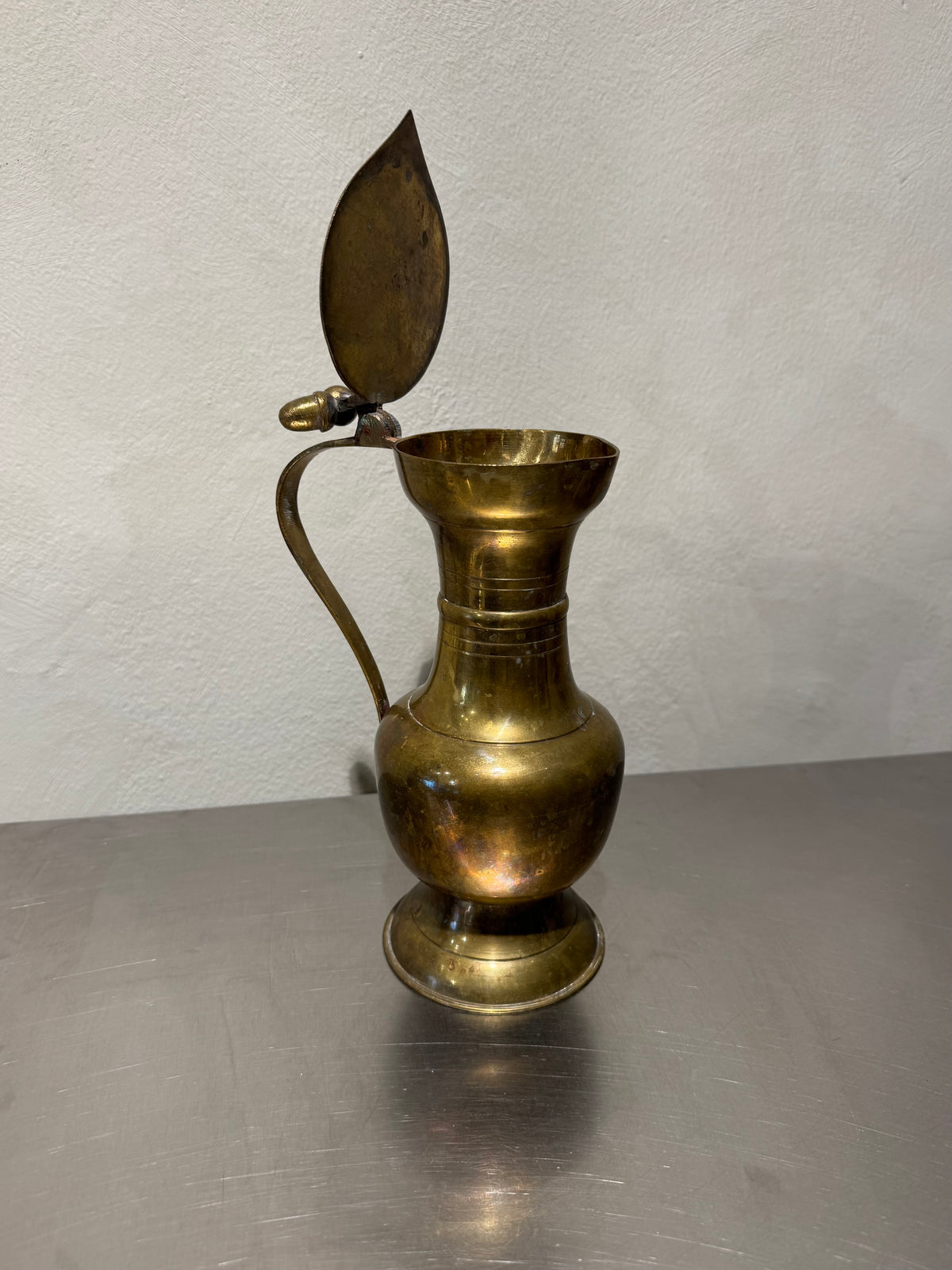 Antique brass pitcher with acorn finial and open lid