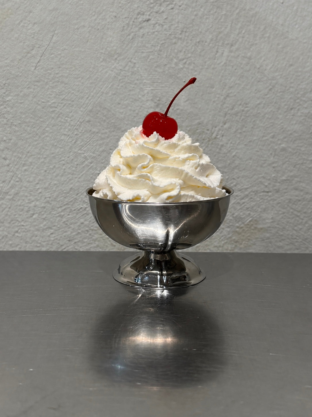 Snäckformad glasskål i rostfritt stål med dessert