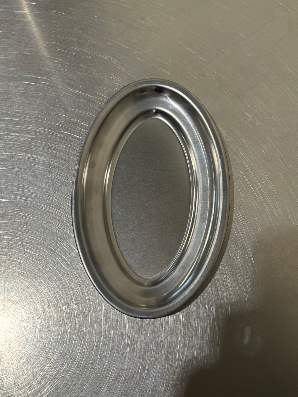 Liten oval serveringsbricka i rostfritt stål