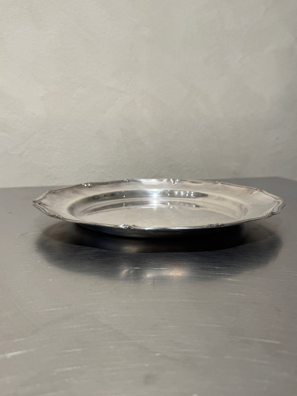 Side view of round silver-plated tray