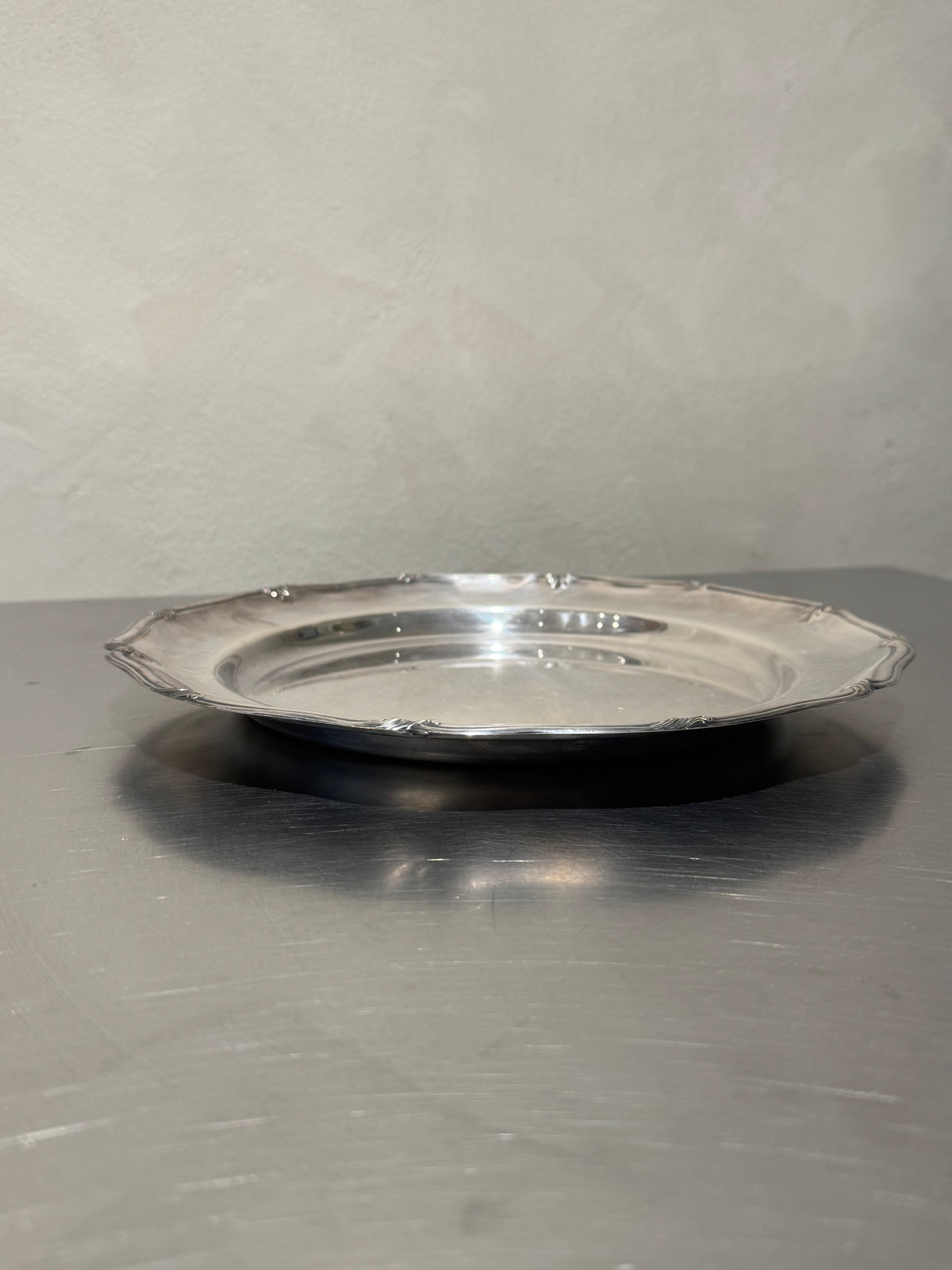 Side view of round silver-plated tray