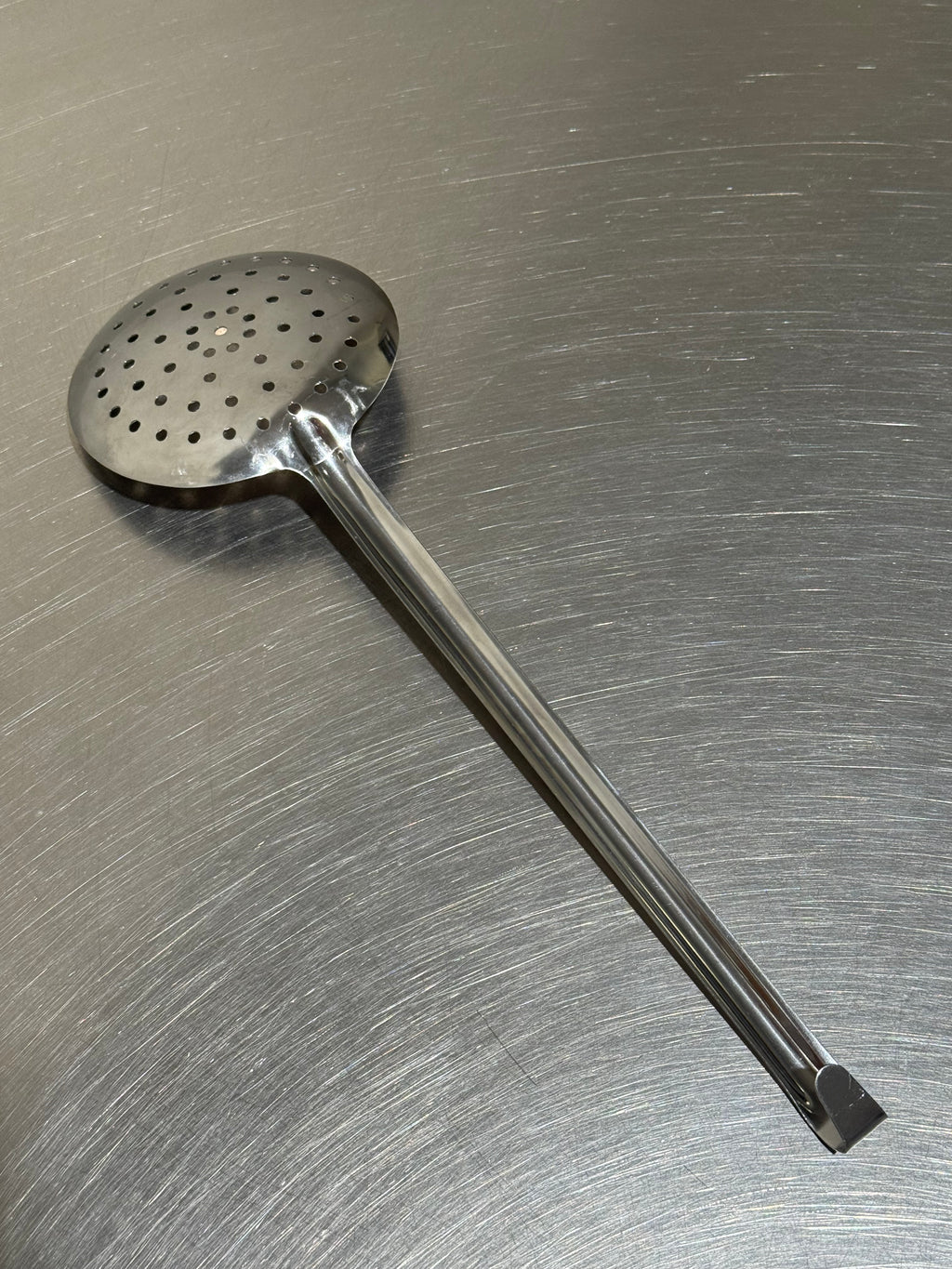 Tomatto stainless-steel slotted spoon, angled view