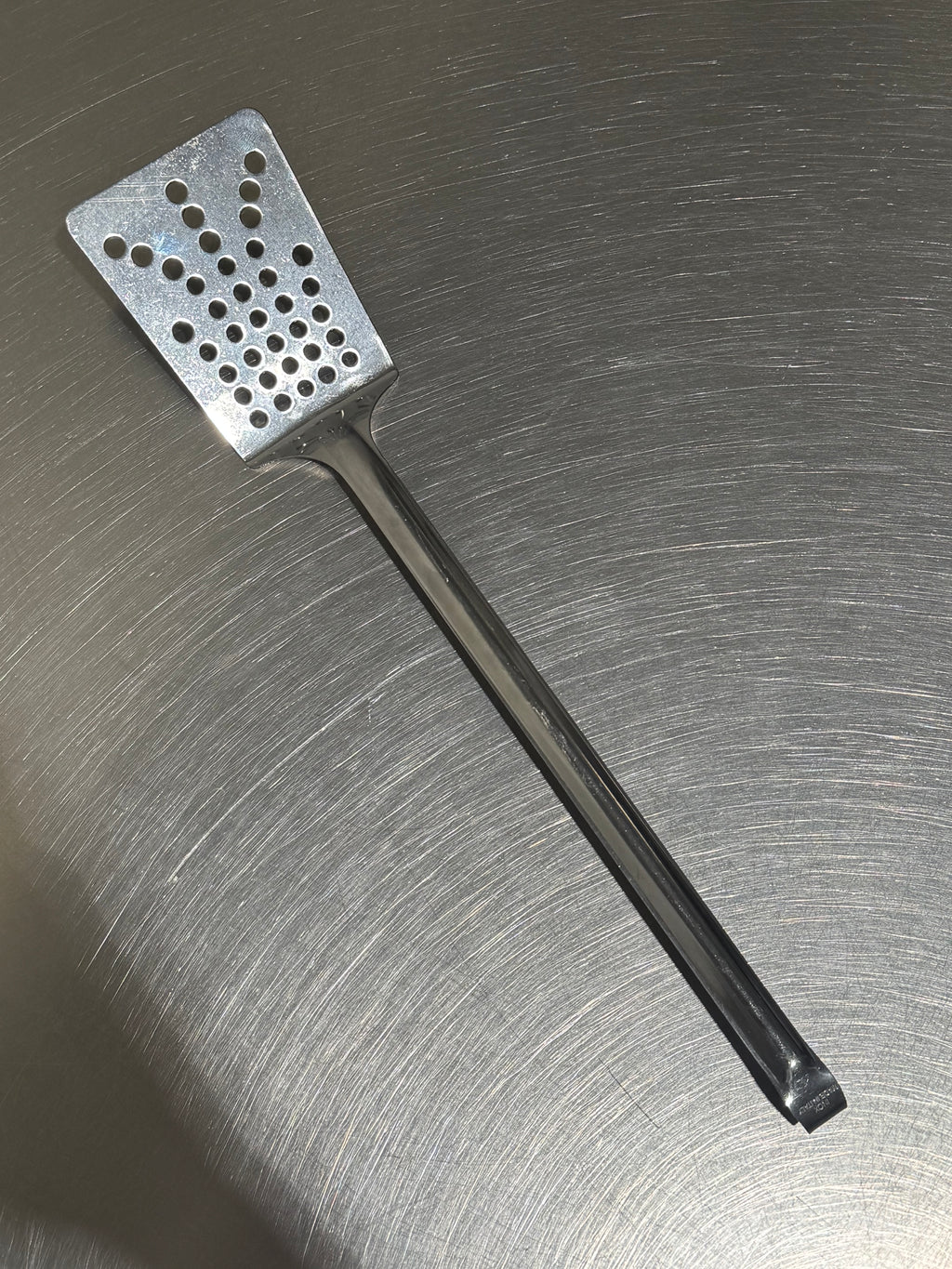 Tomatto stekspade med hål i rostfritt stål framifrån