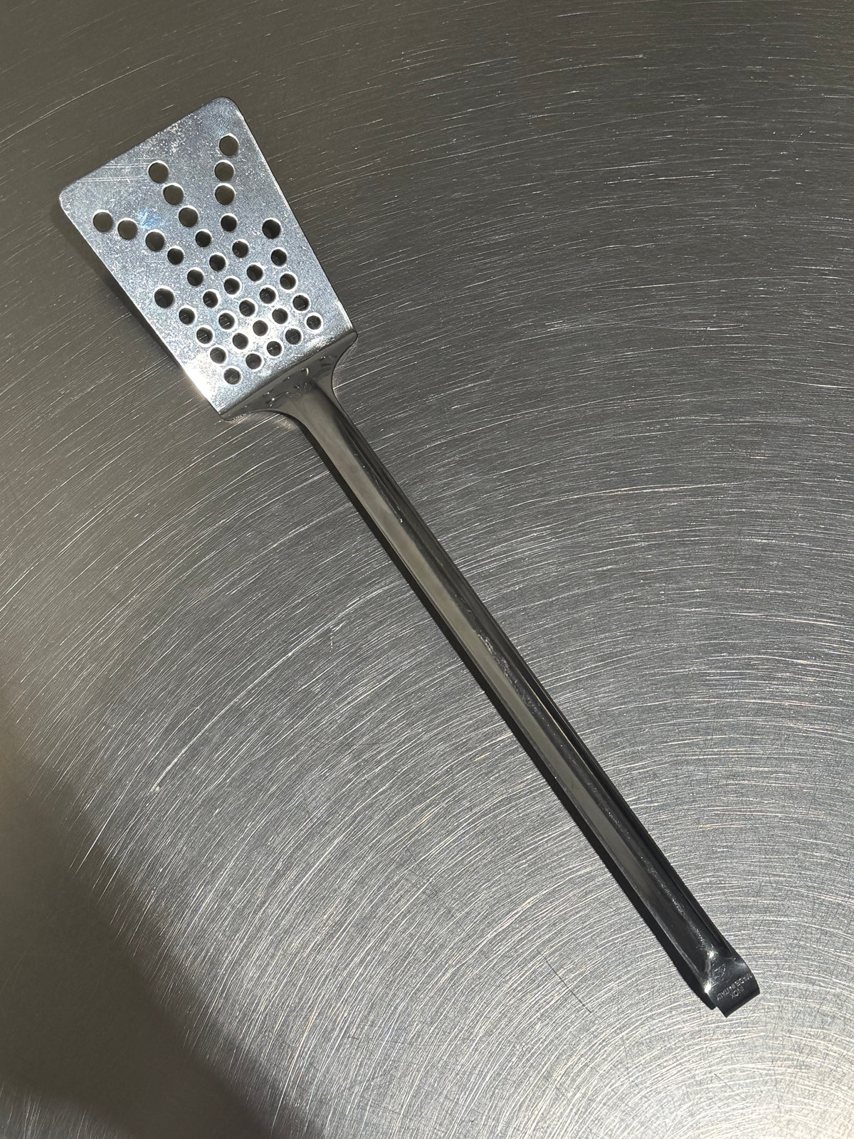 Tomatto stekspade med hål i rostfritt stål framifrån